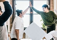 Happy diverse colleagues in a startup company doing a high five