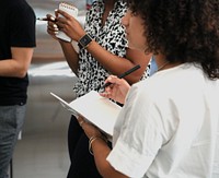 Black women taking down notes at a seminar