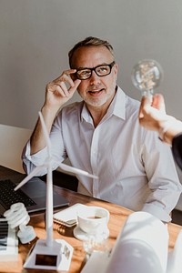 Creative mature man looking at a light bulb