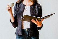 Businesswoman drinking a cup of coffee while checking on her agenda