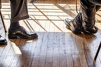 Businessmen with leather shoes on a wooden floor