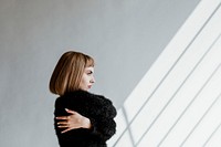 Short hair woman in a black fluffy sweater hugging herself