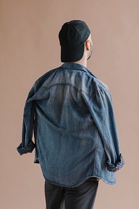 Rearview of a man in a denim jacket with a cap