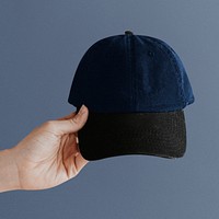 Hand holding a navy blue cap mockup