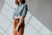 Woman in a blue shirt by the white wall
