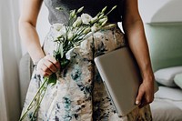 Woman holding white lisianthus and a laptop
