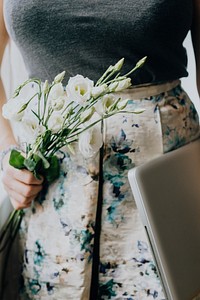 Woman holding white lisianthus and a laptop