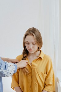 Mom braiding hair for a young girl