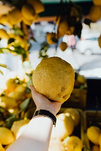 Woman buying a fresh lemon at a market