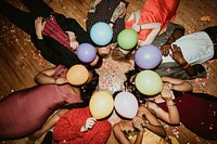 Friends lying on the floor at a party with balloons 