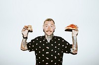 Tattooed man holding a pizza in his hands