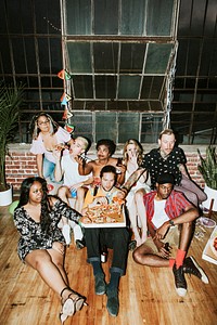 A group of diverse friends enjoying pizza at a party