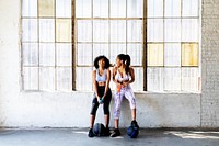 Sportive women talking in a gym while drinking water