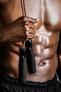 Black American sporty guy holding a skipping rope