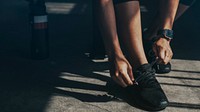 Woman tying her shoelaces, getting ready to exercise wallpaper