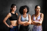 Sportive female personal trainers standing with arms crossed