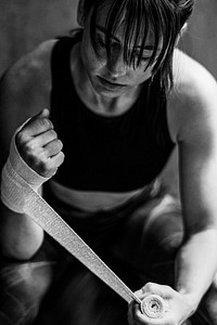 Female boxer putting a strap on her hand