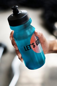 Hand holding a blue water bottle mockup