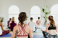 Healthy people doing a Sukhasana yoga pose in a yaga class