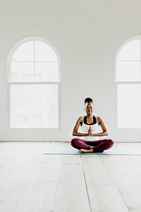 Black lady doing a Sukhasana yoga pose