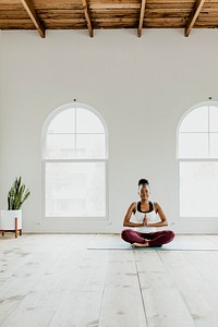 Black lady doing a Sukhasana yoga pose