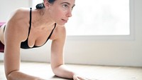 Sportive woman doing elbow plank on the floor