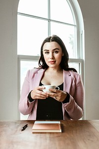 Businesswoman drinking coffee in a meeting room