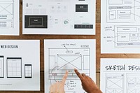 Hands point to web design document 