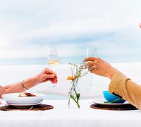 Dating couple&#39;s hands doing a toast with the sky in the background