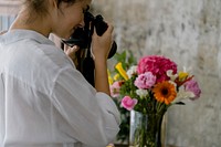 Young girl taking photo of flowers