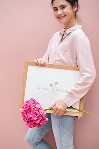 Cute girl holding a frame mockup with pink hydrangeas