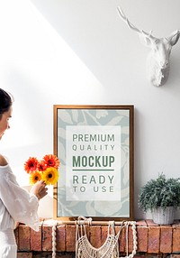 Girl decorating a wall with a frame mockup