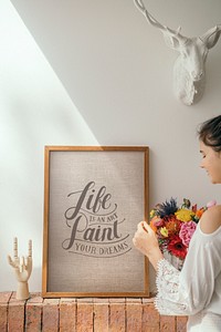 Girl decorating a wall with a motivational frame