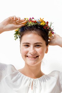 Beautiful young woman with a midsummer floral wreath