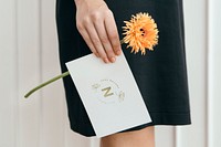 Woman with an orange gerbera spider and a card mockup