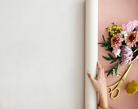 Florist rolling out a white banner on a pink desk