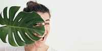 Cheerful woman with a split leaf philodendron