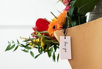 Fresh colorful flowers in a brown bag with a card mockup