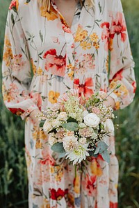 Woman in a floral dress holding a flower bouquet