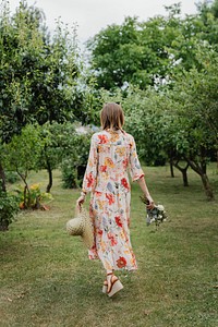 Woman in a floral dress walking in a garden