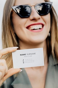 Friendly woman in sunglasses carrying a business card mockup