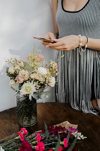 Woman taking a photo of flowers with a phone