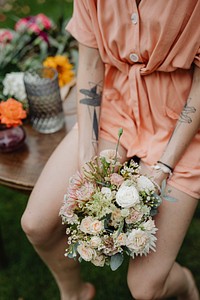 Woman in an orange jumpsuit with a bouquet of flowers