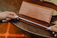 Woman measuring a leather wallet