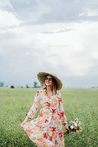 Cheerful woman in a floral dress in a field