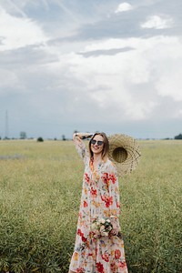 Cheerful woman in a floral dress in a field