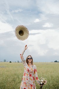 Cheerful woman in a floral dress in a field