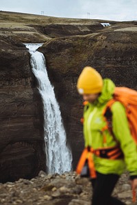 Woman in a green jacket at the Haifoss waterfall, Iceland
