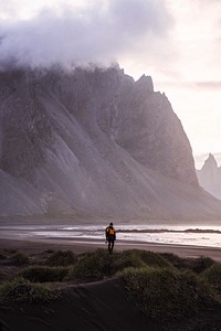 Photographer on a green hill at the Stokksnes peninsula in Southeast Iceland