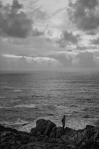 Man standing on the rocks by the beach
